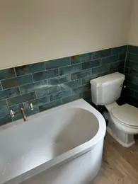 Luxury Essex bathroom with freestanding bath, brass taps and teal tiles