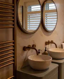 Luxury Essex bathroom with double vessel sinks, brass taps and heated towel rail