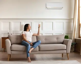Woman turning on air conditioning in her living room