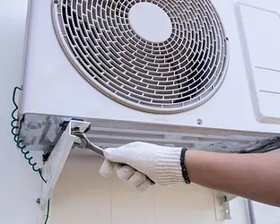 Technician installing outdoor air conditioning unit