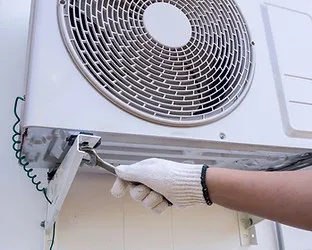 Technician installing outdoor air conditioning unit