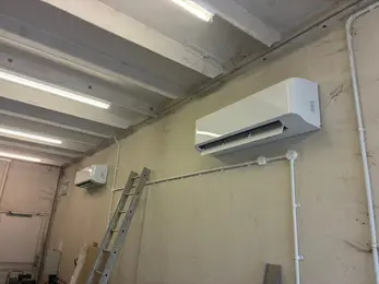 Wall-mounted air conditioning units installed in a commercial workshop.