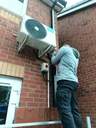 Outdoor AC isolator and electrical connection beside a Midea condenser
