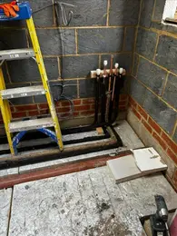 New boiler installation in progress with copper pipework and floorboards lifted