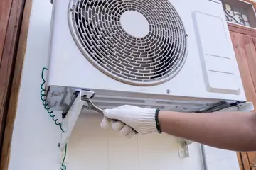 technician installing outdoor air conditioning unit